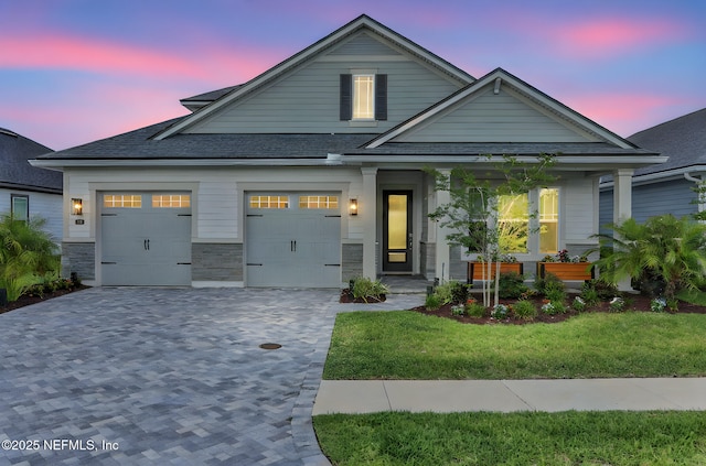 181 Lamego Ln, Saint Augustine, FL 32095 - view of front of home featuring decorative driveway, covered porch, roof with shingles, a front lawn, and an attached garage