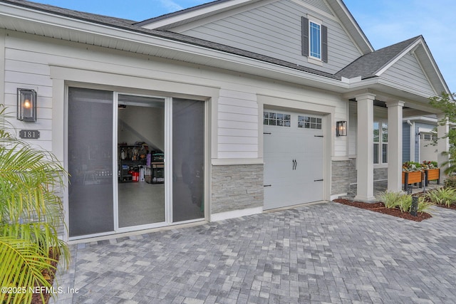 181 Lamego Ln, Saint Augustine, FL 32095 - entrance to property with driveway, stone siding, and roof with shingles