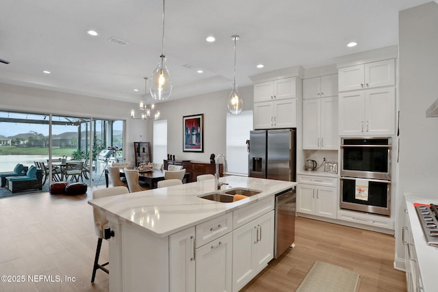 181 Lamego Ln, Saint Augustine, FL 32095 - kitchen featuring stainless steel appliances, a sink, white cabinetry, recessed lighting, and light wood-style floors