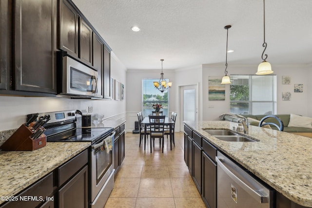 1500 Calming Water Dr Unit 3504, Fleming Island, FL 32003 - kitchen with appliances with stainless steel finishes, a sink, ornamental molding, dark brown cabinets, and a chandelier