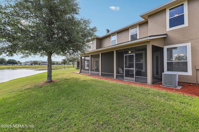 1500 Calming Water Dr Unit 3504, Fleming Island, FL 32003 - rear view of house featuring central air condition unit, a sunroom, a lawn, a water view, and stucco siding