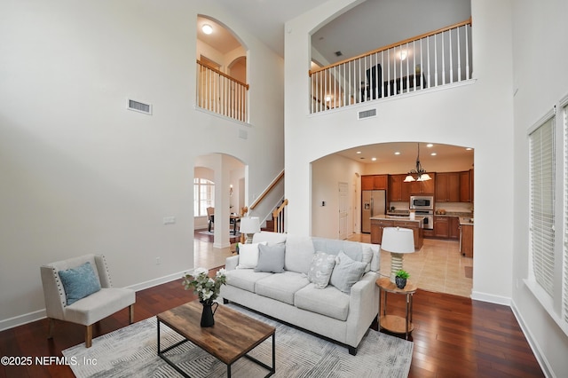 5279 Cattle Crossing Way, Jacksonville, FL 32226 - living room featuring arched walkways, hardwood / wood-style floors, visible vents, and stairway