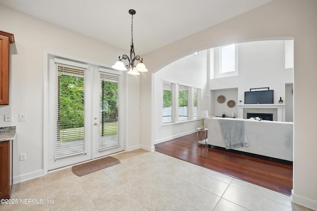 5279 Cattle Crossing Way, Jacksonville, FL 32226 - entryway featuring light tile patterned floors, a fireplace, a notable chandelier, baseboards, and arched walkways