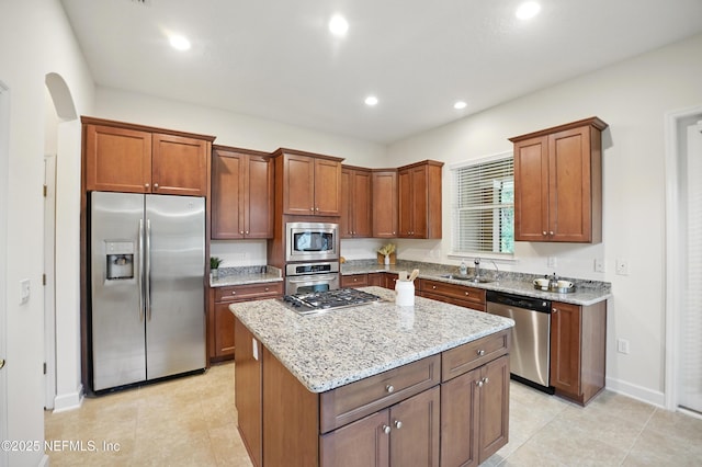 5279 Cattle Crossing Way, Jacksonville, FL 32226 - kitchen featuring a center island, a sink, stainless steel appliances, light stone countertops, and light tile patterned flooring