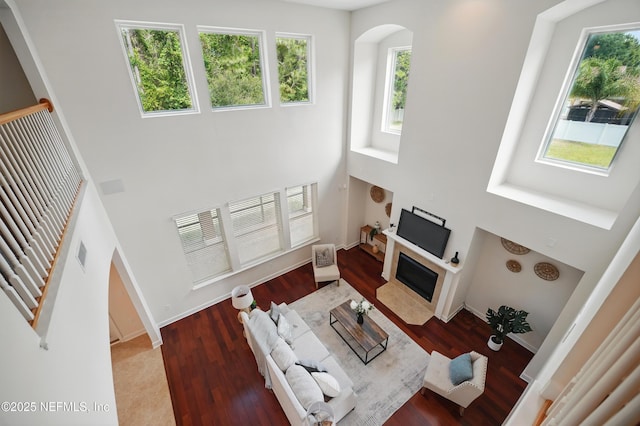 5279 Cattle Crossing Way, Jacksonville, FL 32226 - living room with a towering ceiling, arched walkways, a fireplace with flush hearth, and wood finished floors
