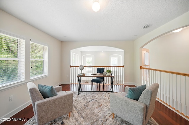 5279 Cattle Crossing Way, Jacksonville, FL 32226 - living area with wood finished floors, a textured ceiling, visible vents, arched walkways, and baseboards