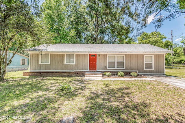 single story home featuring a front yard, roof with shingles, and fence