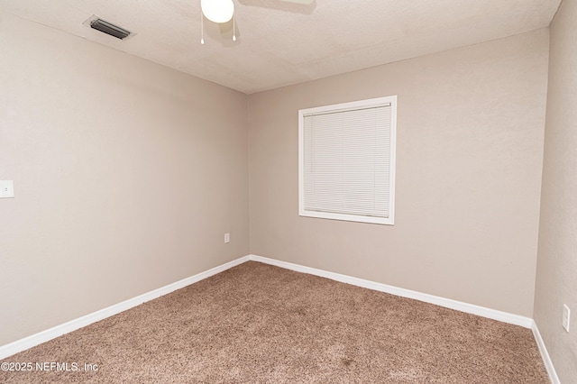 carpeted empty room featuring a ceiling fan, baseboards, and visible vents