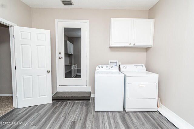 610 S 9th St, Macclenny, FL 32063 - washroom with washing machine and dryer, light wood-style flooring, cabinet space, and visible vents