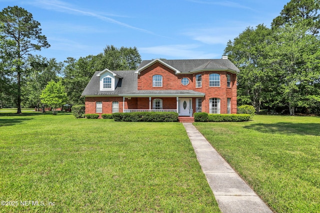 12602 Wimica Ln, Jacksonville, FL 32218 - colonial-style house with covered porch, brick siding, a front yard, and a chimney