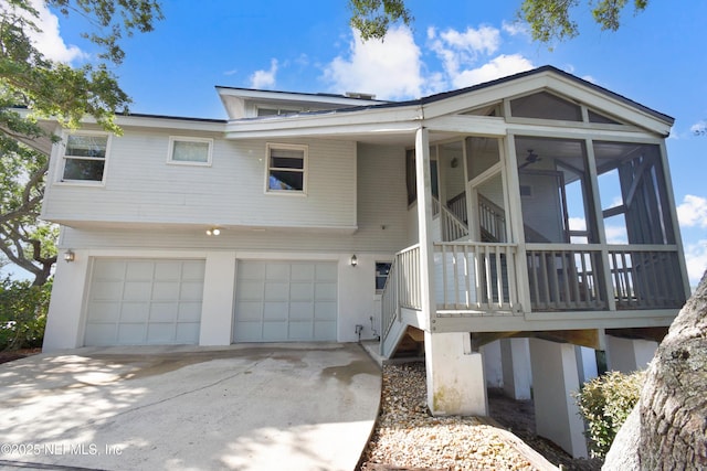 view of front of house with an attached garage, a sunroom, driveway, and stairs