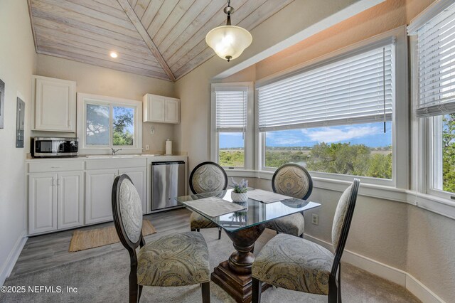 dining area featuring plenty of natural light, wood ceiling, baseboards, lofted ceiling, and light wood-style flooring