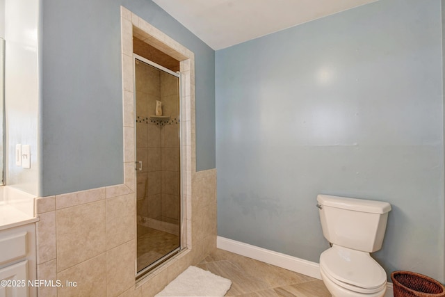 full bath with a shower stall, tile patterned floors, toilet, vanity, and baseboards
