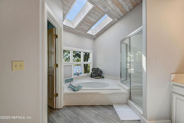 full bath with a skylight, a stall shower, a garden tub, vanity, and wood ceiling