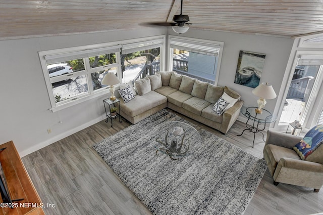 living room featuring plenty of natural light, vaulted ceiling, a ceiling fan, wood ceiling, and baseboards