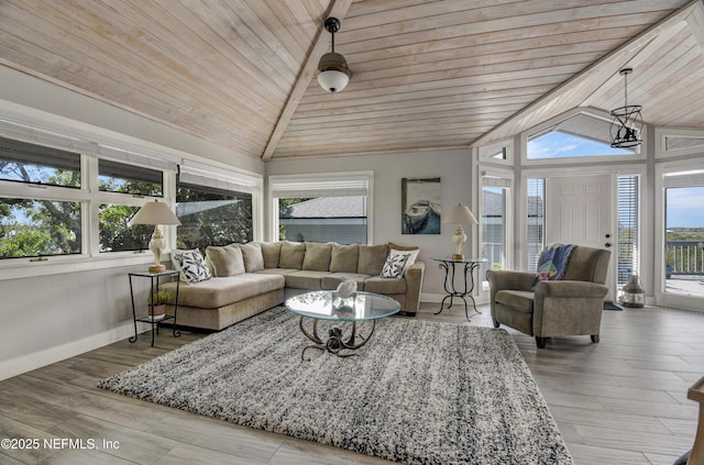 living room with lofted ceiling, wooden ceiling, baseboards, and wood finished floors