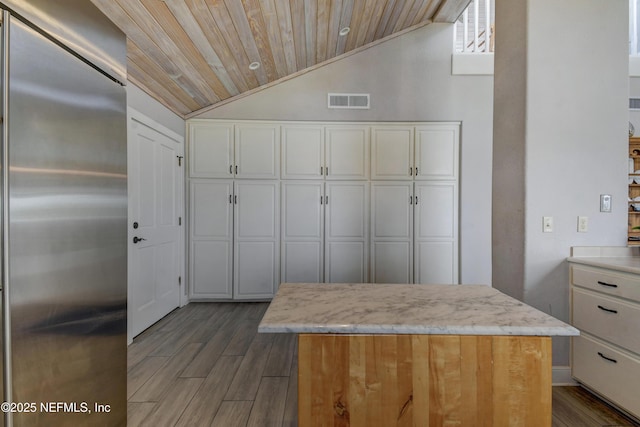 kitchen with built in fridge, wood ceiling, lofted ceiling, white cabinets, and dark wood-style floors