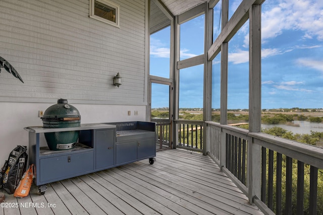 sunroom with a water view and area for grilling
