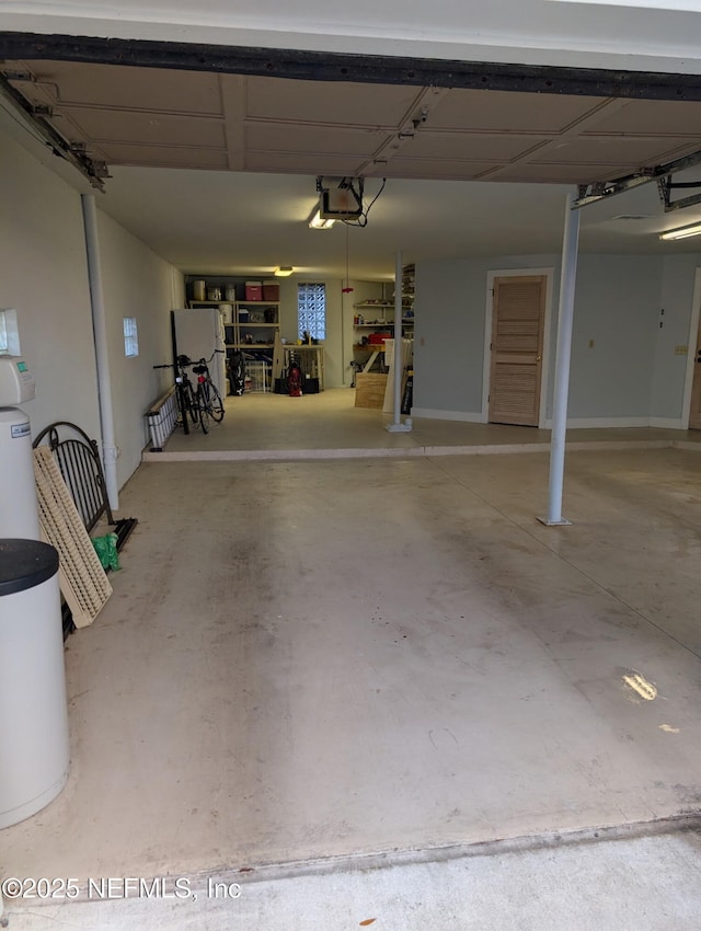 garage with a garage door opener and freestanding refrigerator