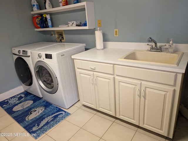 clothes washing area with washing machine and clothes dryer, cabinet space, and light tile patterned floors