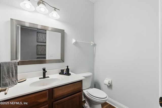 bathroom with vanity, toilet, and wood finished floors
