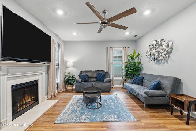 living area featuring ceiling fan, wood finished floors, a fireplace, and recessed lighting