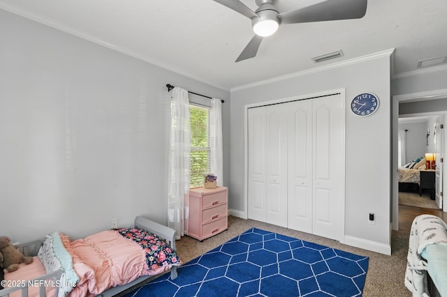 carpeted bedroom with ornamental molding, a closet, baseboards, and a ceiling fan