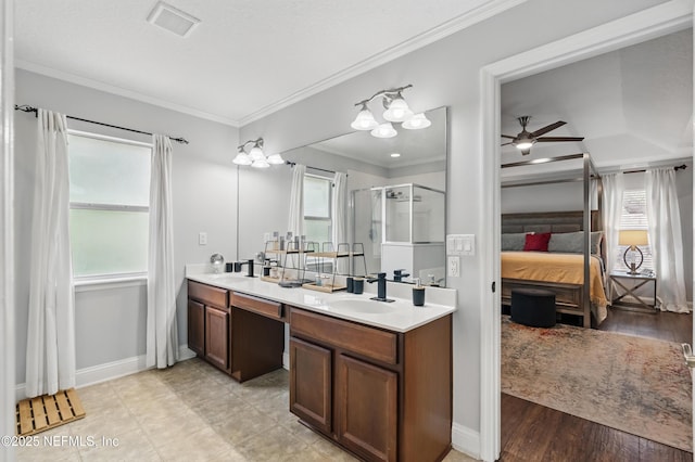 ensuite bathroom with a shower stall, double vanity, a ceiling fan, ornamental molding, and baseboards