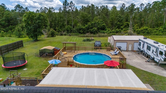 4384 Hickory St, Macclenny, FL 32063 - view of swimming pool with a trampoline, a forest view, and an outdoor structure