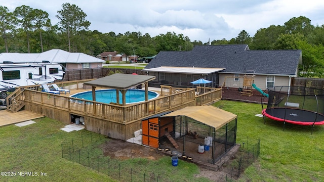 4384 Hickory St, Macclenny, FL 32063 - view of swimming pool featuring a trampoline, a wooden deck, and a playground