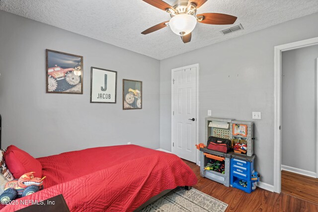 4384 Hickory St, Macclenny, FL 32063 - bedroom featuring wood finished floors, a textured ceiling, baseboards, and a ceiling fan