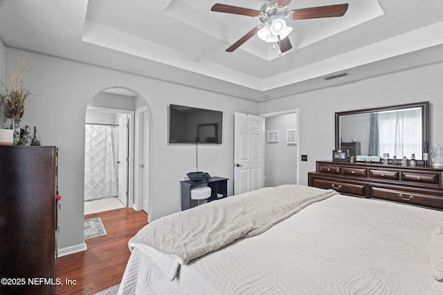 4384 Hickory St, Macclenny, FL 32063 - bedroom featuring a raised ceiling, arched walkways, wood finished floors, a ceiling fan, and ensuite bathroom