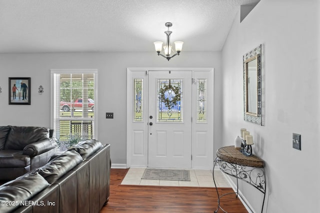 4384 Hickory St, Macclenny, FL 32063 - foyer entrance with wood finished floors, a textured ceiling, a chandelier, and baseboards