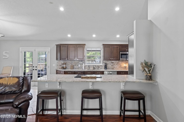 4384 Hickory St, Macclenny, FL 32063 - kitchen with appliances with stainless steel finishes, a breakfast bar, decorative backsplash, and recessed lighting