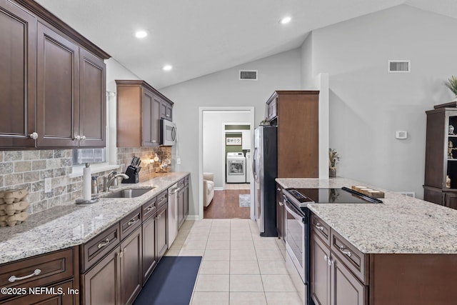 4384 Hickory St, Macclenny, FL 32063 - kitchen featuring appliances with stainless steel finishes, a sink, vaulted ceiling, washer / clothes dryer, and a peninsula