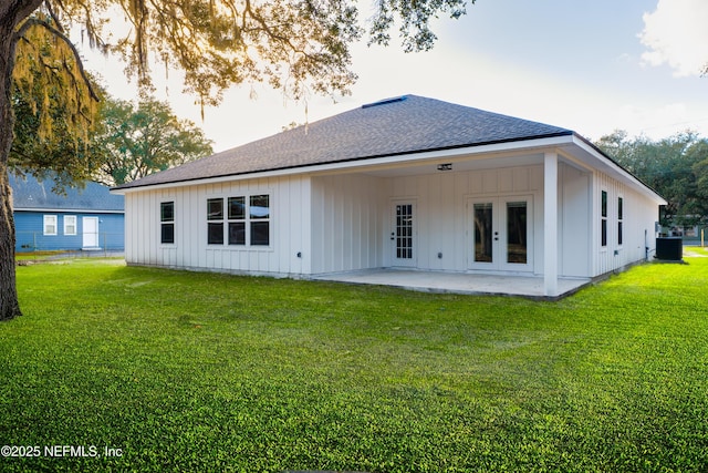 back of property featuring board and batten siding, roof with shingles, a patio area, french doors, and a lawn
