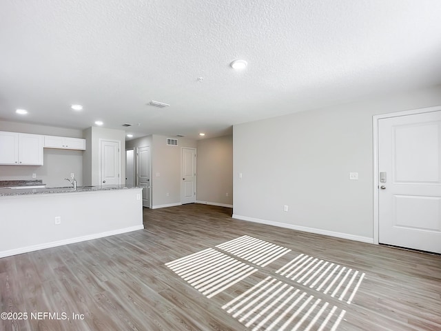 11462 Oakfield Ct, Jacksonville, FL 32258 - unfurnished living room with a textured ceiling, visible vents, baseboards, light wood-style floors, and recessed lighting