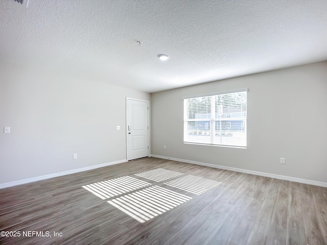 11462 Oakfield Ct, Jacksonville, FL 32258 - spare room with baseboards, a textured ceiling, and wood finished floors