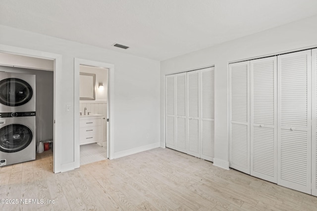 2032 Sea Hawk Cir, Ponte Vedra Beach, FL 32082 - unfurnished bedroom with estacked washer and dryer, two closets, light wood finished floors, baseboards, and ensuite bath