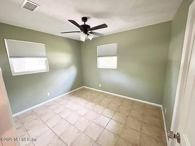 10306 Jolynn Rd, Jacksonville, FL 32225 - empty room with healthy amount of natural light, ceiling fan, light tile patterned floors, and baseboards