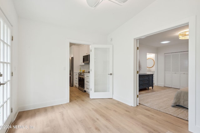 2537 Dauphine Ct E, Ponte Vedra Beach, FL 32082 - unfurnished bedroom featuring freestanding refrigerator, light wood-style flooring, baseboards, and a wood stove