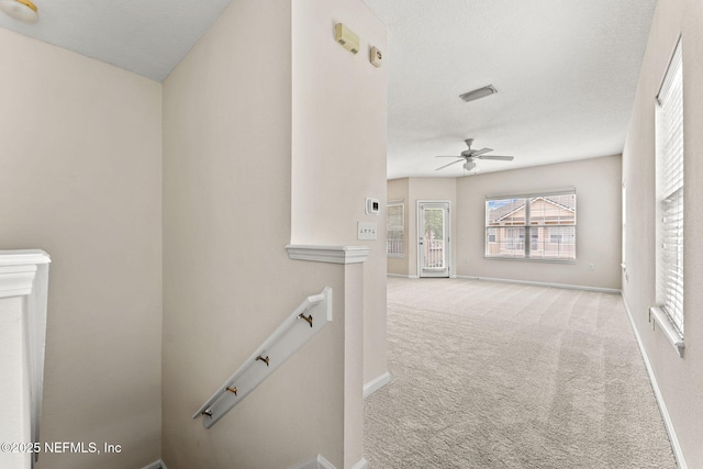hall featuring an upstairs landing, carpet floors, and baseboards