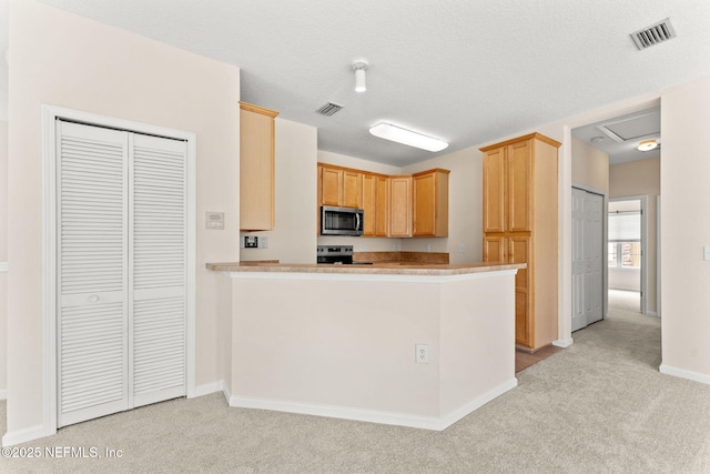 kitchen featuring appliances with stainless steel finishes, light carpet, baseboards, and light countertops