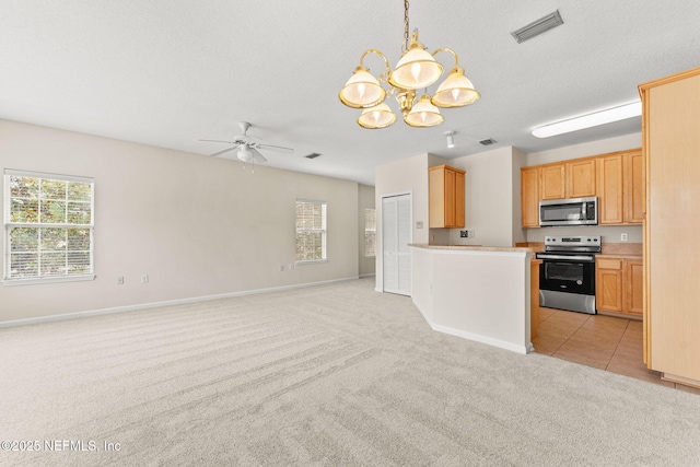 kitchen featuring appliances with stainless steel finishes, light colored carpet, open floor plan, a ceiling fan, and a chandelier