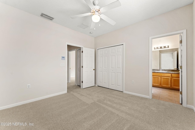unfurnished bedroom with light colored carpet, baseboards, a sink, and a closet