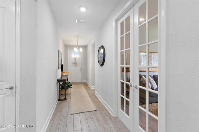 169 Rivercliff Trl, Saint Augustine, FL 32092 - hallway featuring french doors, baseboards, and light wood-style flooring