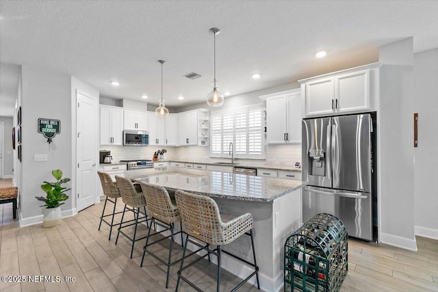 169 Rivercliff Trl, Saint Augustine, FL 32092 - kitchen featuring stainless steel appliances, baseboards, a sink, backsplash, and light wood-style flooring
