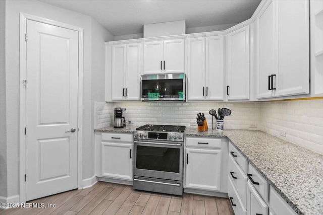 169 Rivercliff Trl, Saint Augustine, FL 32092 - kitchen with stainless steel appliances, light wood-type flooring, white cabinets, and backsplash