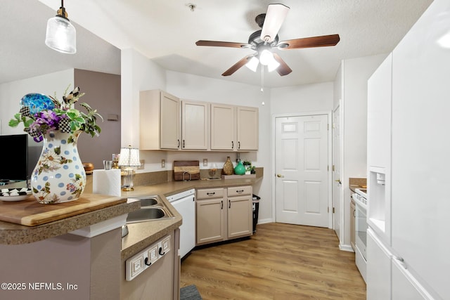kitchen featuring a ceiling fan, white appliances, light wood finished floors, hanging light fixtures, and light countertops