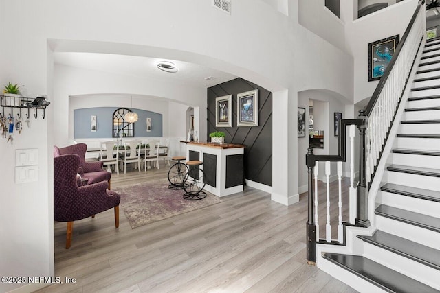 11698 Donato Dr, Jacksonville, FL 32226 - entrance foyer featuring stairs, light wood-style flooring, arched walkways, baseboards, and a towering ceiling